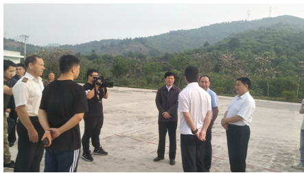罗试坚指挥长(右四)在机场停机坪听取南方航空护林站谢应敏站长工作情况汇报